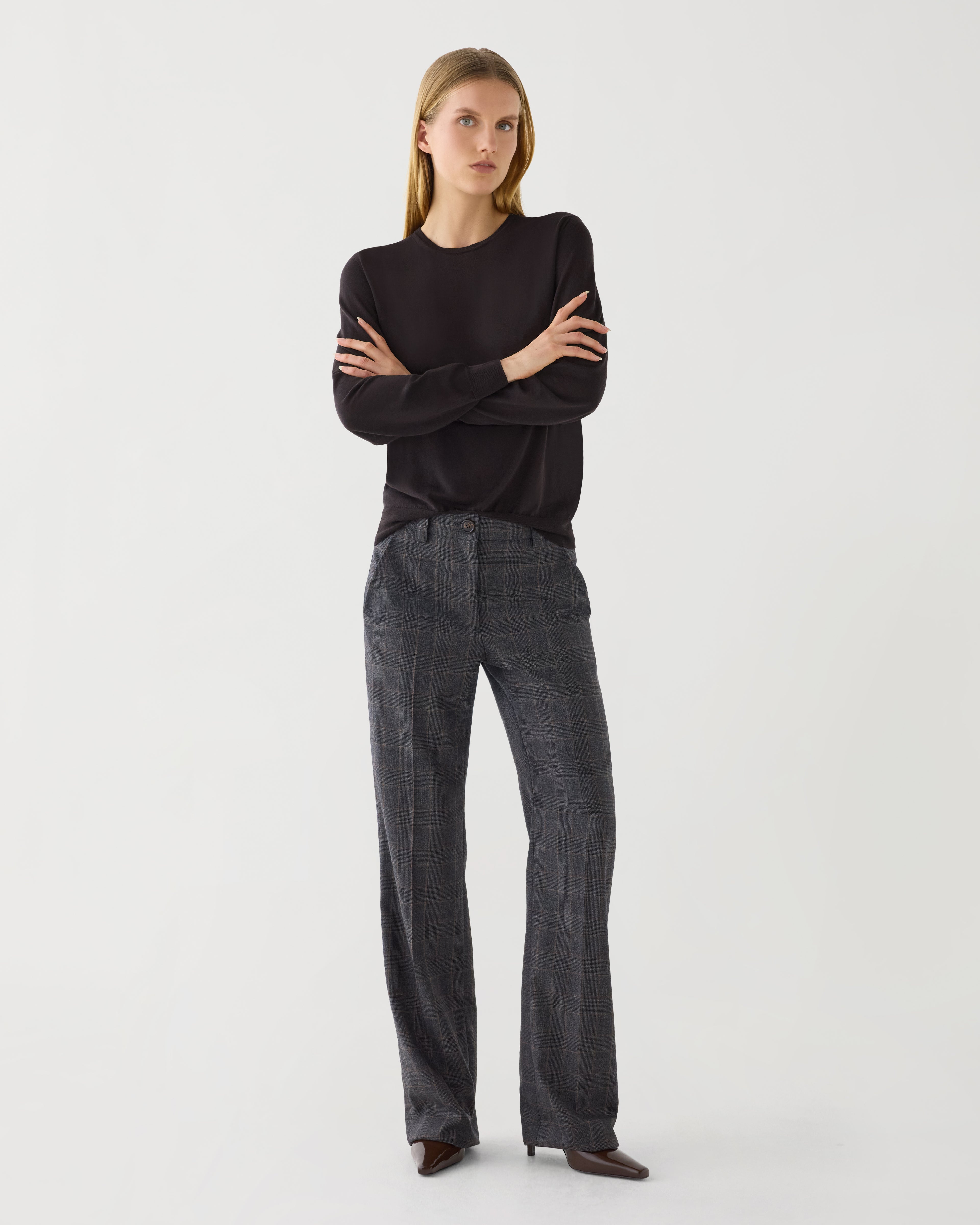 Dark grey plaid Avery trousers displayed on a hanger, showcasing the sleek fabric and tailored fit for stylish bottoms.