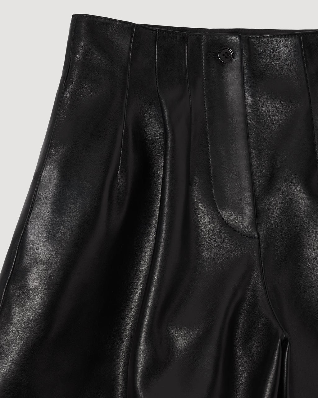 Black Tilly Short packshot. Lightweight nappa leather, high waist, pleated front, horn button. Tailored luxury women's bottoms