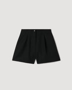 Black Tilly Short in Grain de Poudre wool packshot. High-waisted, pleated tailored shorts with a horn button front closure