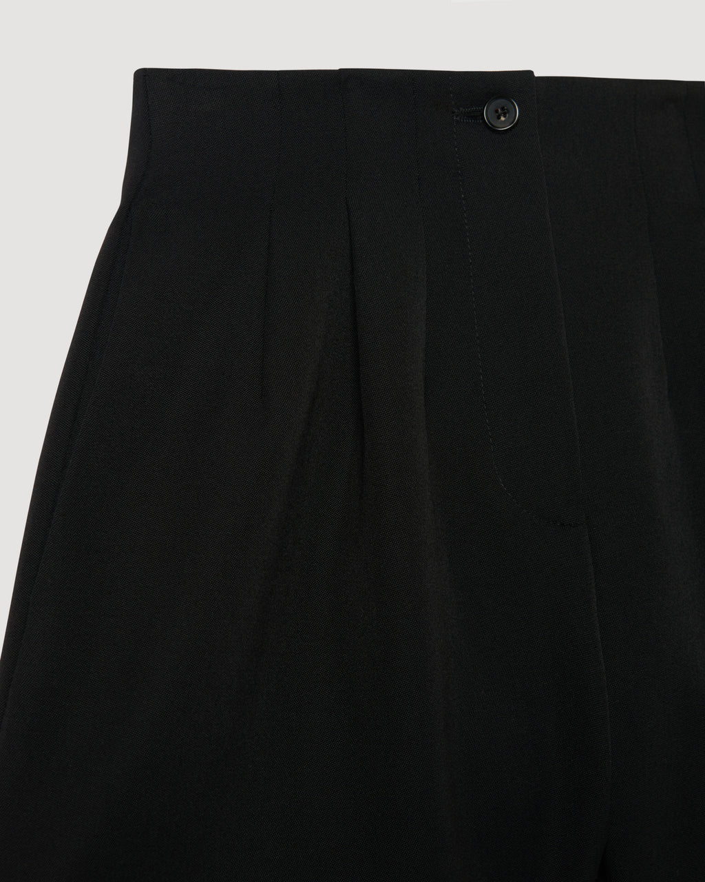 Black Tilly Short packshot. High-waist Grain de Poudre wool shorts with pleated front, horn button