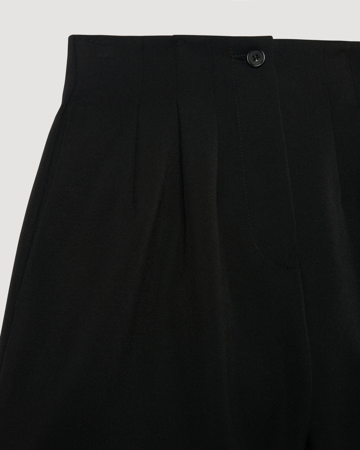 Black Tilly Short packshot. High-waist Grain de Poudre wool shorts with pleated front, horn button