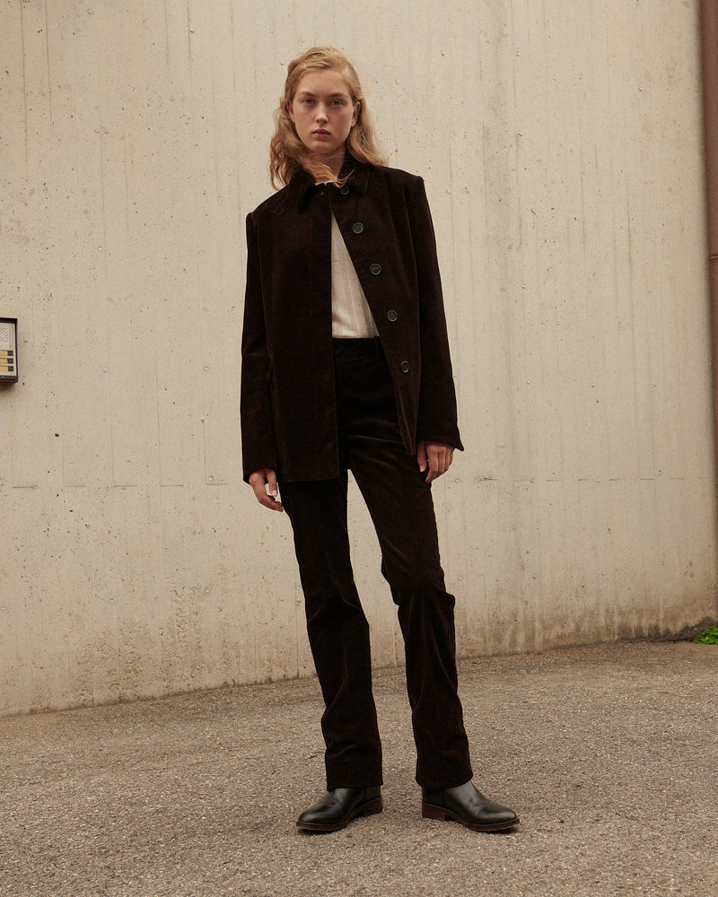 Women's dark brown corduroy oversized jacket and trousers set, styled with black leather ankle boots