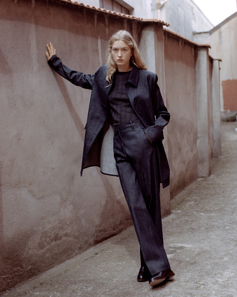 Blonde model wears dark indigo denim oversized blazer, ribbed knit top, wide-leg trousers Luxury women's denim suiting