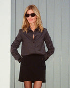 Black Sabine skirt by Veronica De Piante in stretch wool twill fabric, shown hanging on a white background.