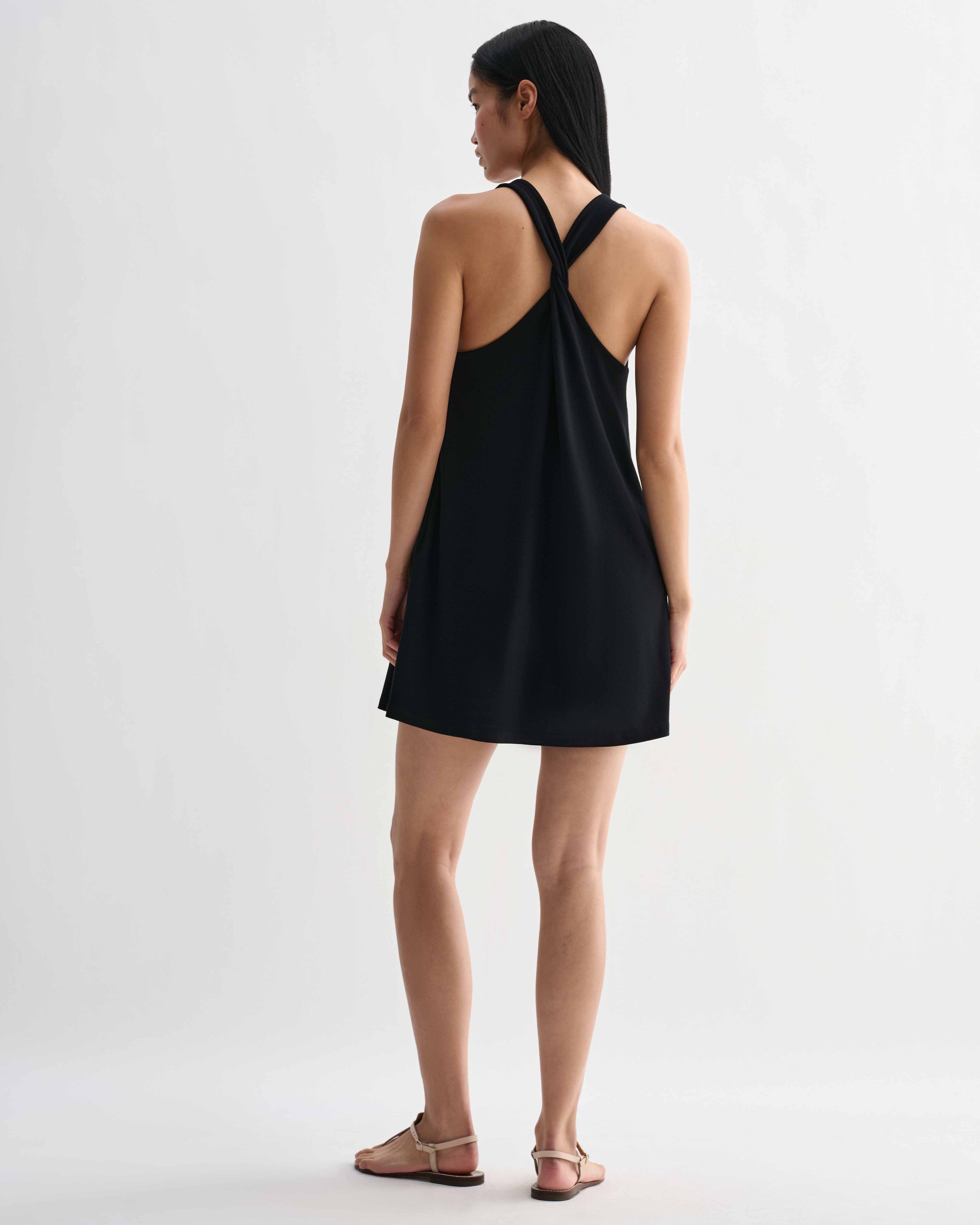 Black Vittoria dress by Veronica De Piante in stretch viscose jersey, shown on a hanger with a close-up of fabric texture and design details.